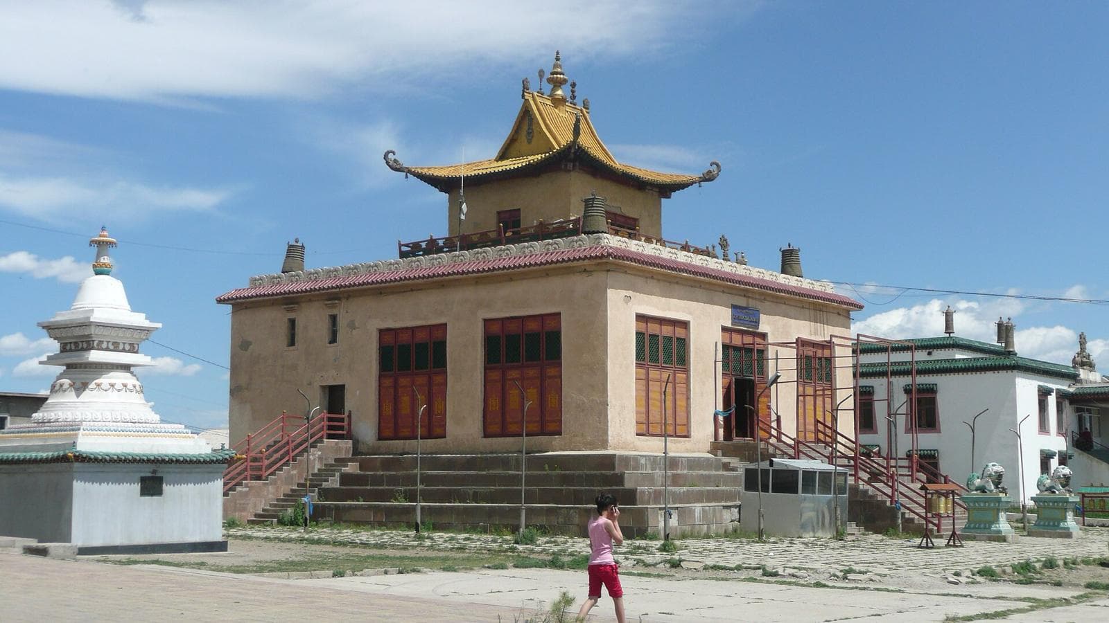 A temple at Gandan Monastery with a gilded roof under a blue sky